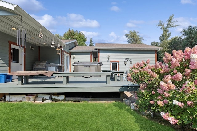 rear view of property featuring a wooden deck and a lawn