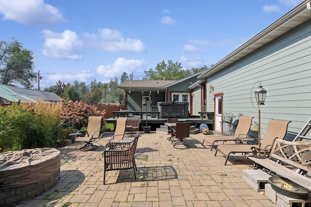 view of patio with a hot tub and an outdoor fire pit