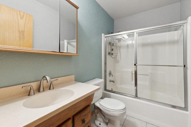 bathroom with vanity, bath / shower combo with glass door, tile patterned floors, toilet, and a textured wall