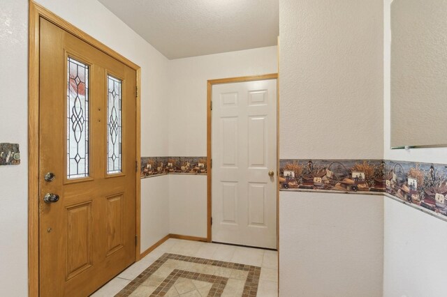 tiled entryway with a textured ceiling