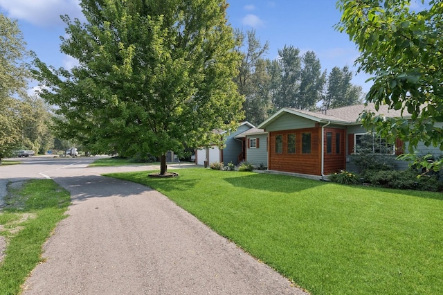 view of front facade with a front yard, an attached garage, and driveway