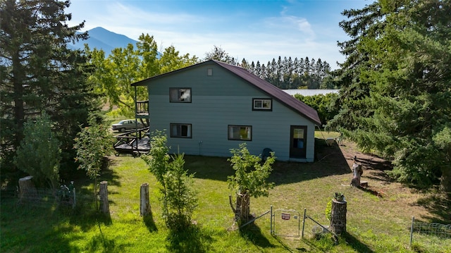 view of side of home featuring a mountain view and a lawn