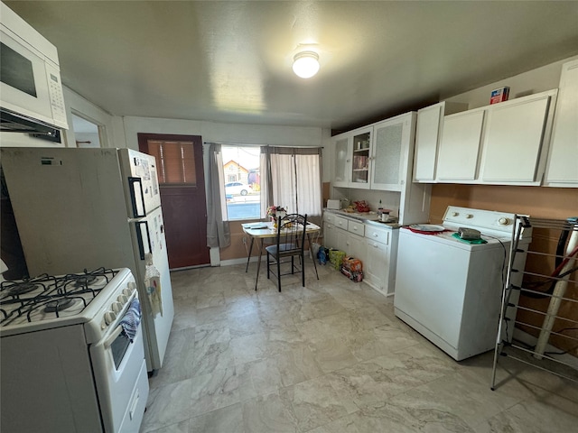 kitchen with washer / clothes dryer, white appliances, and white cabinets