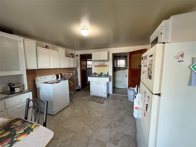 kitchen with washer / clothes dryer, white refrigerator, and white cabinetry