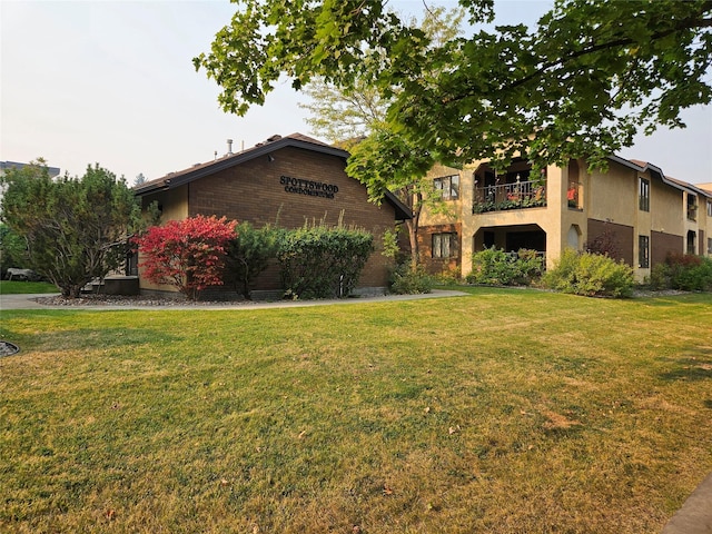 view of front of property featuring a balcony and a front yard