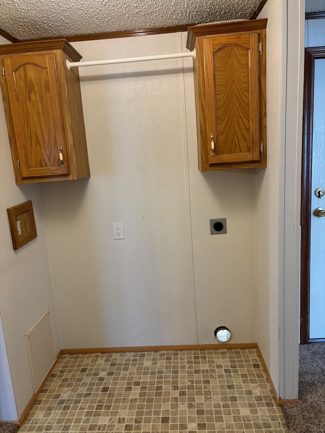 laundry area with electric dryer hookup, baseboards, and cabinet space