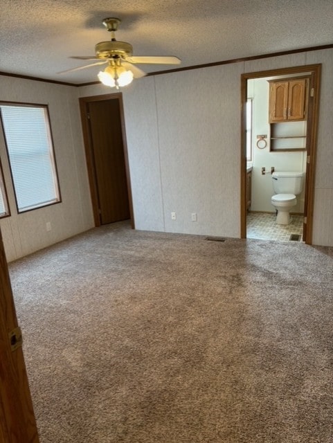 unfurnished bedroom featuring light carpet, a textured ceiling, and ornamental molding