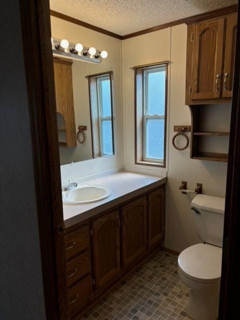 half bathroom with toilet, crown molding, a textured ceiling, and vanity