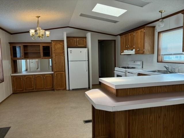 kitchen with under cabinet range hood, lofted ceiling, brown cabinets, white appliances, and a sink