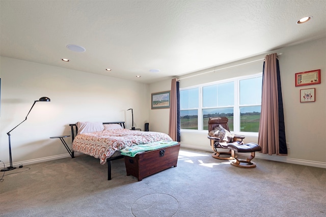 bedroom featuring light carpet and a textured ceiling