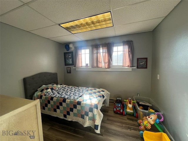 bedroom featuring a paneled ceiling and dark hardwood / wood-style floors