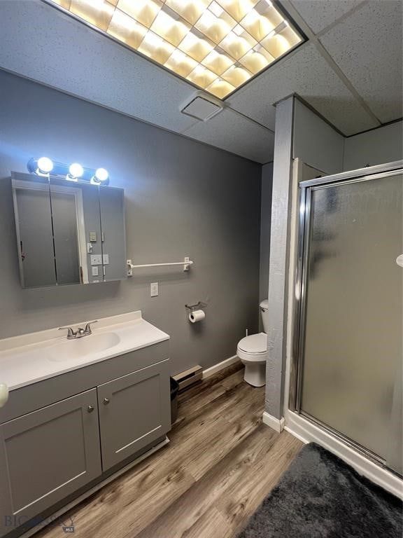 bathroom featuring hardwood / wood-style floors, a shower with shower door, vanity, and toilet