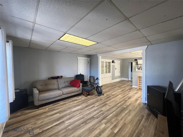 living room with hardwood / wood-style floors and a paneled ceiling