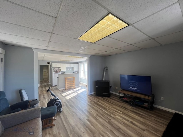 living room featuring hardwood / wood-style floors and a paneled ceiling