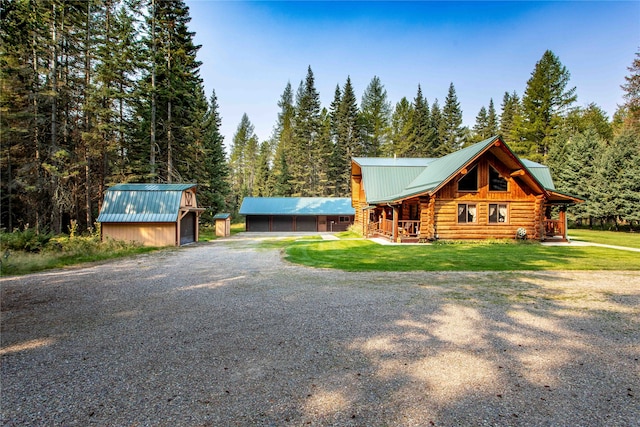 view of front of home with a storage unit, a front yard, and a garage