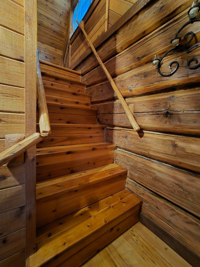 stairway featuring wood walls and hardwood / wood-style floors