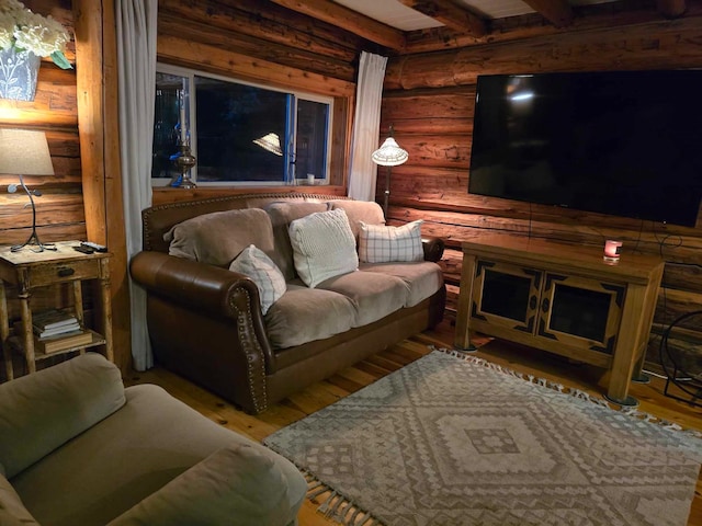 living room with rustic walls, wood-type flooring, and beamed ceiling