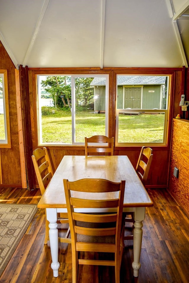 dining area with lofted ceiling, plenty of natural light, and dark hardwood / wood-style flooring