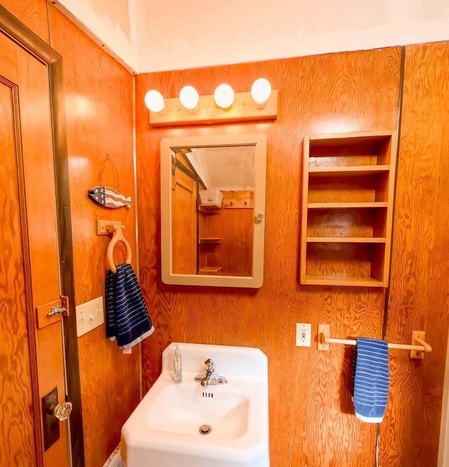 bathroom featuring sink and wooden walls