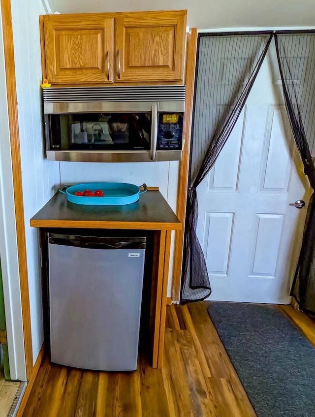 kitchen with appliances with stainless steel finishes and hardwood / wood-style flooring