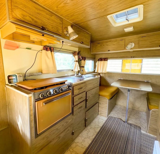 kitchen with wood ceiling, electric range, and wooden walls