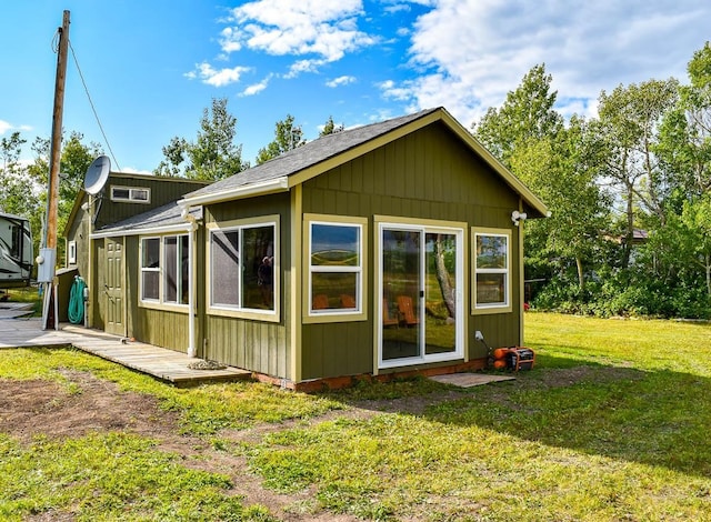 rear view of property featuring a lawn