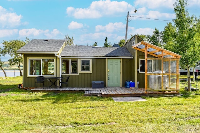 rear view of property featuring a deck and a lawn