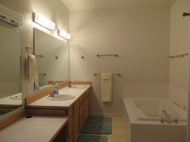 bathroom with tile patterned flooring, vanity, and a bathtub