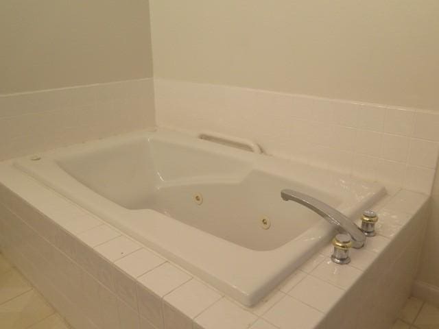 bathroom featuring tile patterned flooring and a tub with jets