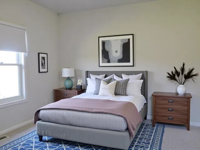 carpeted bedroom featuring baseboards and visible vents