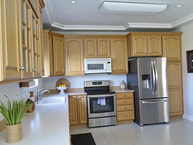 kitchen with stainless steel appliances, recessed lighting, light countertops, and a sink