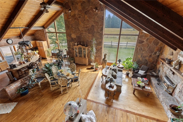 living area featuring wooden ceiling, lofted ceiling with beams, wood finished floors, and a wealth of natural light