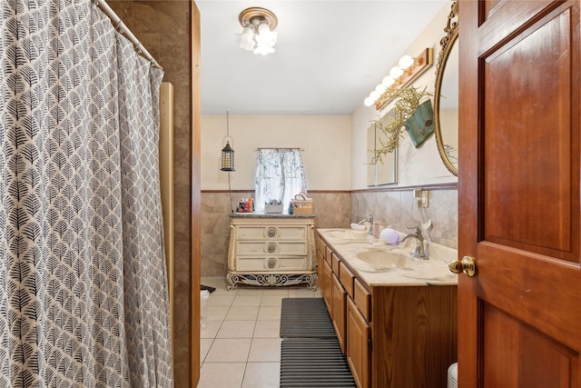 bathroom with vanity, a shower with shower curtain, wainscoting, tile walls, and tile patterned floors