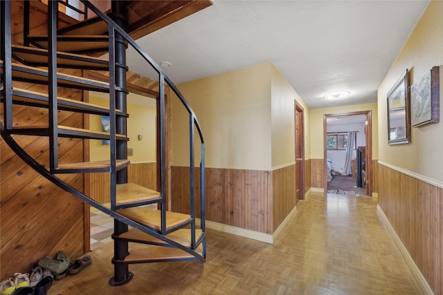 stairway featuring wood walls and wainscoting