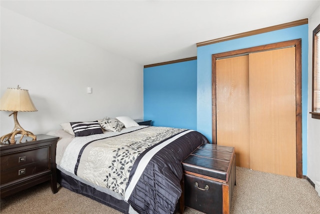 carpeted bedroom with a closet and ornamental molding