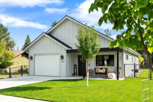 view of front of house with a gate, board and batten siding, an attached garage, and a front lawn