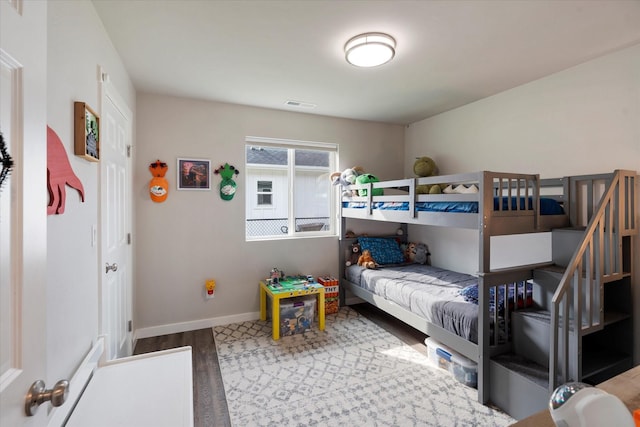 bedroom featuring baseboards, visible vents, and wood finished floors