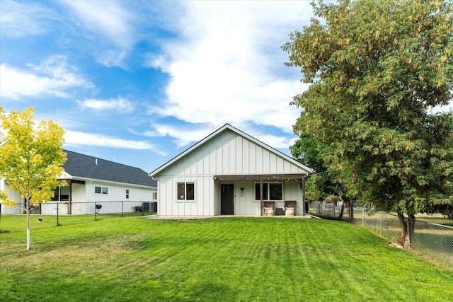 back of property with a lawn, central air condition unit, board and batten siding, and a fenced backyard