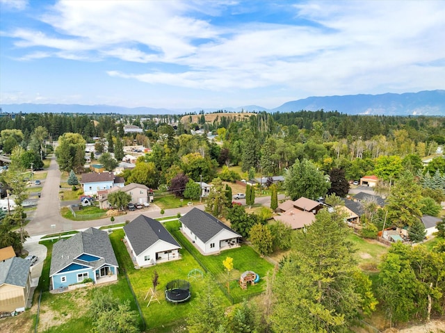 birds eye view of property featuring a view of trees, a mountain view, and a residential view