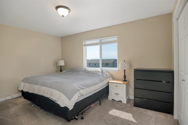 bedroom featuring light colored carpet and baseboards