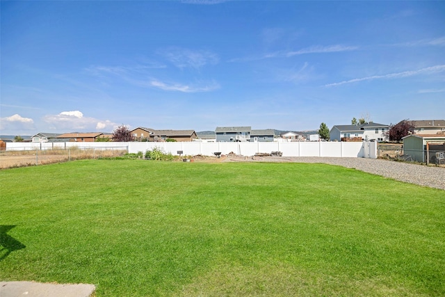 view of yard featuring a fenced backyard and a residential view