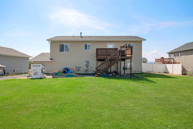 back of property featuring a yard, a wooden deck, stairs, and fence