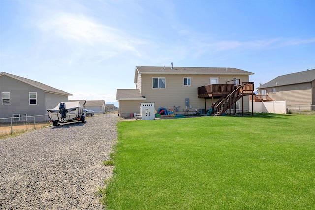 rear view of property with stairway, a lawn, a fenced backyard, and a deck