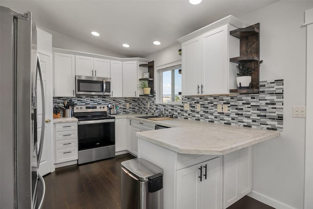 kitchen with open shelves, a sink, appliances with stainless steel finishes, a peninsula, and vaulted ceiling