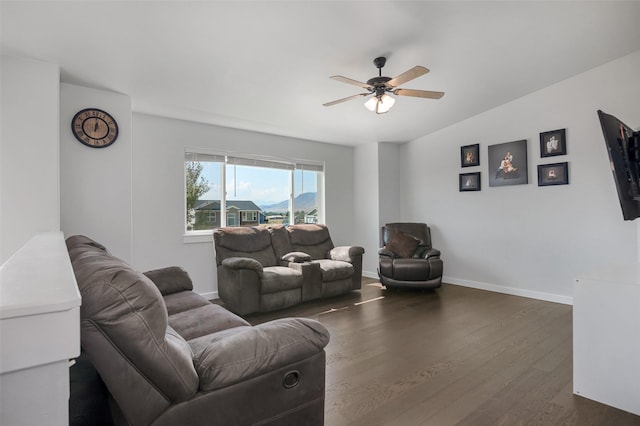 living area with dark wood-style floors, a ceiling fan, lofted ceiling, and baseboards