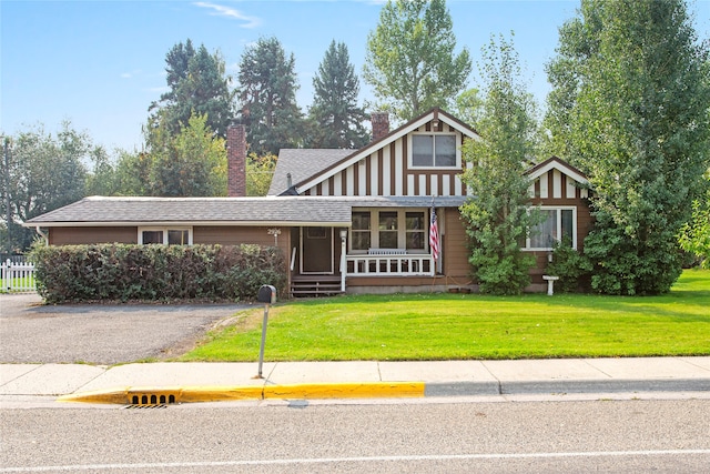 view of front of property featuring a front yard and a sunroom