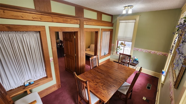 carpeted dining area featuring a textured ceiling