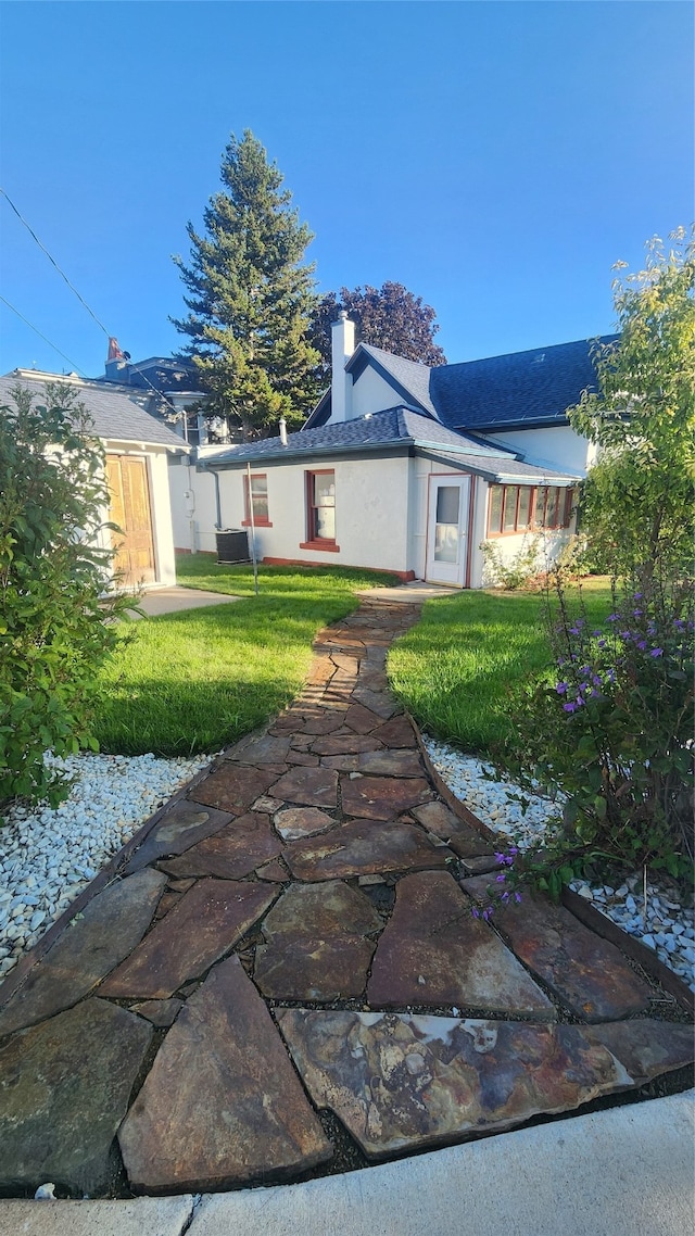 rear view of property featuring cooling unit, a lawn, and a patio