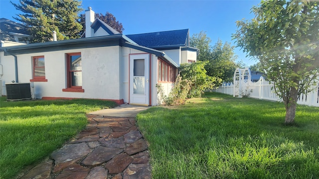 view of front of house with cooling unit and a front yard