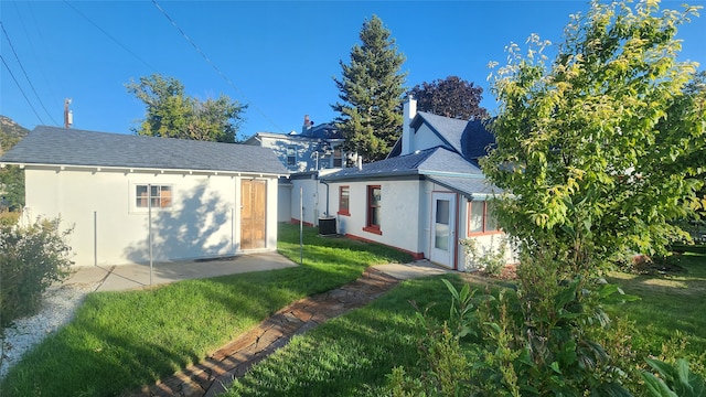 rear view of house featuring central AC, a yard, and a patio